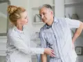 Kobieta wspiera mężczyznę z bólem w okolicy stawy żebrowo kręgowe.