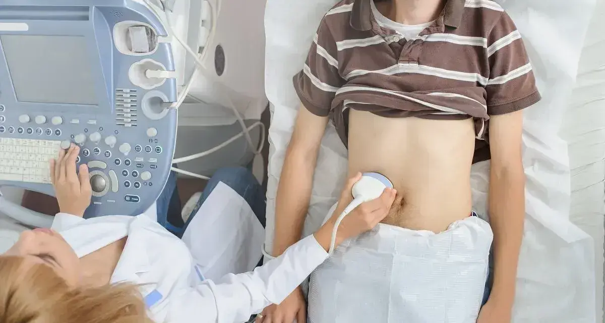 Lekarz wykonuje badanie USG brzucha pacjenta, sprawdzając jego narządy wewnętrzne. Może to pomóc w diagnostyce problemów z wyrostkiem kolczystym C7.