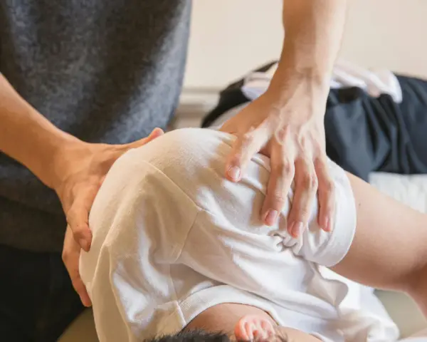 Fizjoterapeuta bada ramię pacjenta, szukając odpowiedzi na pytanie, czy uszkodzony nerw się regeneruje.