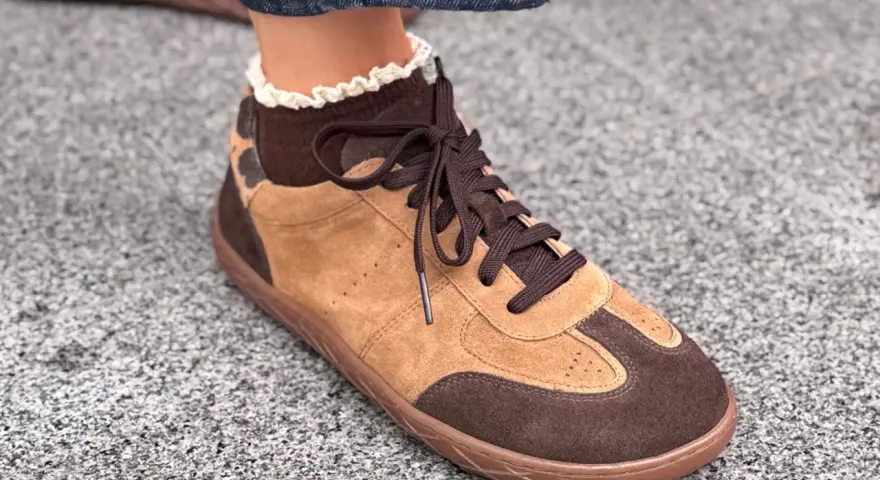 Brązowe buty sportowe z zamszu z koronkowym wykończeniem skarpetki.